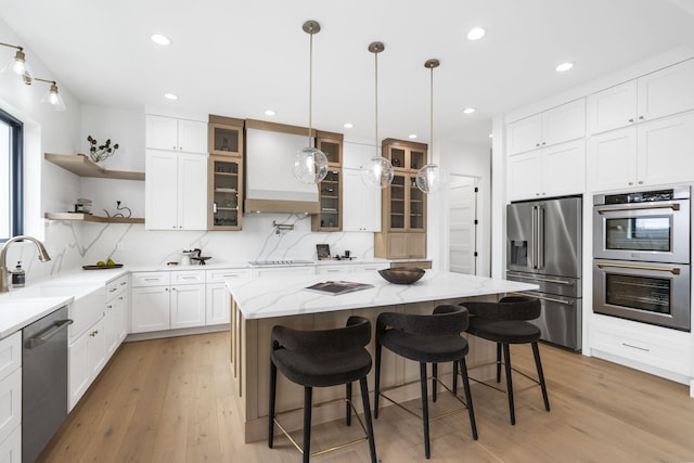 kitchen featuring a kitchen breakfast bar, sink, a kitchen island, and appliances with stainless steel finishes