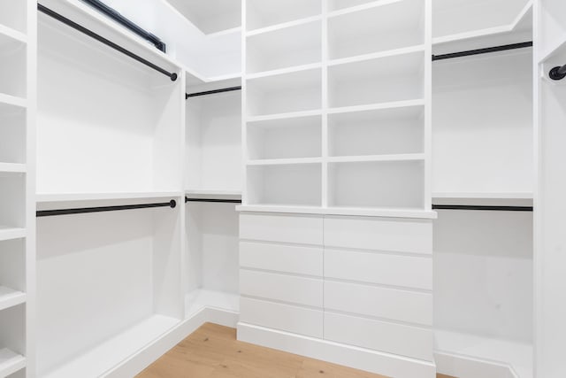 walk in closet with light hardwood / wood-style flooring