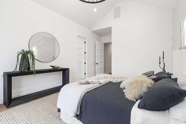 bedroom with hardwood / wood-style floors and lofted ceiling