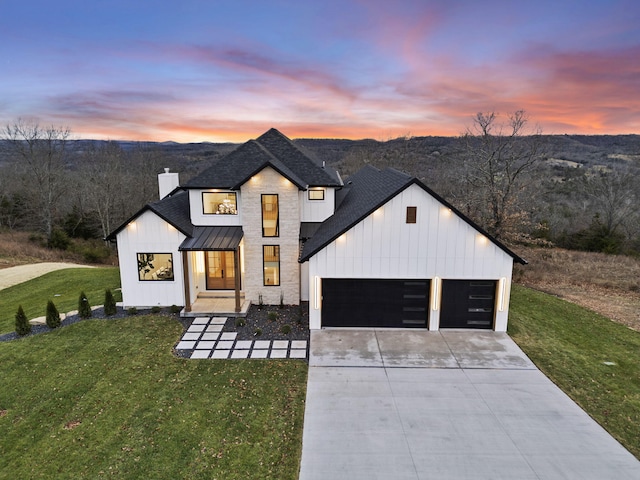 modern farmhouse featuring a lawn and a garage