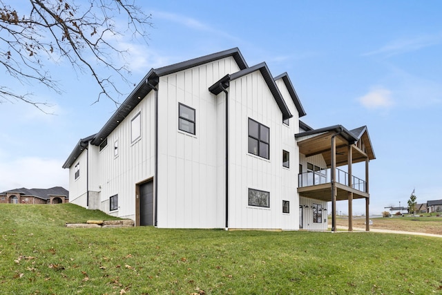 view of side of property with a garage, a yard, and a balcony