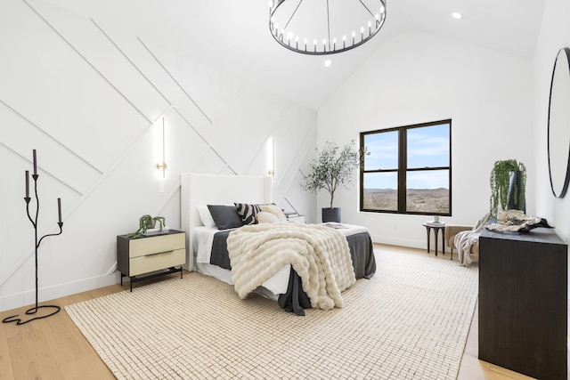 bedroom featuring light hardwood / wood-style flooring and high vaulted ceiling