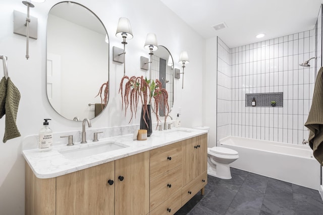 full bathroom featuring tile patterned floors, vanity, toilet, and tiled shower / bath combo