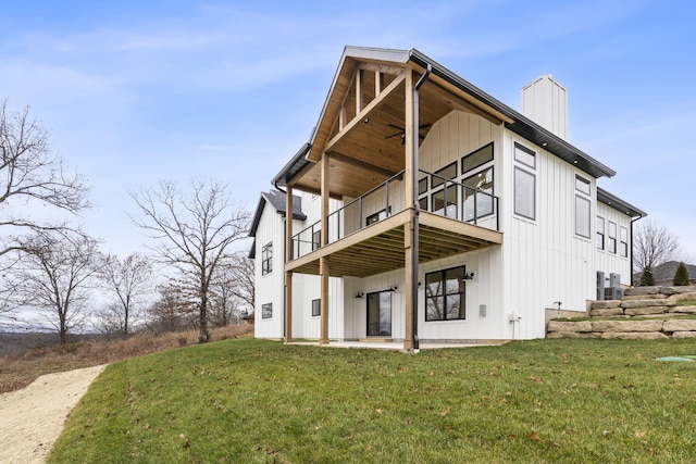 rear view of property featuring a lawn, a patio area, and a balcony