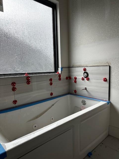 bathroom with a tub and a wealth of natural light