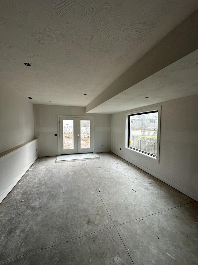 unfurnished room featuring a textured ceiling and french doors