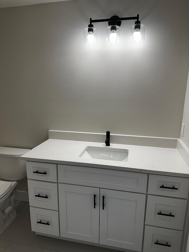 bathroom with vanity, tile patterned floors, and toilet