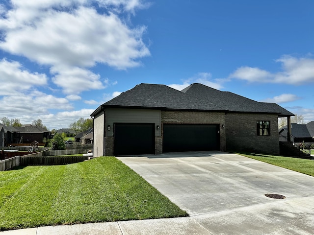 view of side of home featuring driveway, a garage, brick siding, fence, and a yard
