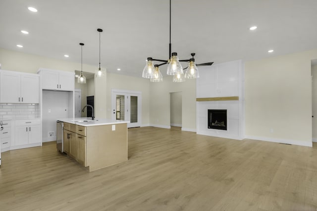 702 S Thornridge Dr, Springfield, MO 65809 - kitchen featuring stainless steel dishwasher, a sink, open floor plan, decorative backsplash, and light countertops