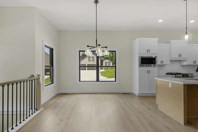 702 S Thornridge Dr, Springfield, MO 65809 - kitchen featuring stainless steel microwave, light wood-type flooring, tasteful backsplash, white cabinets, and recessed lighting