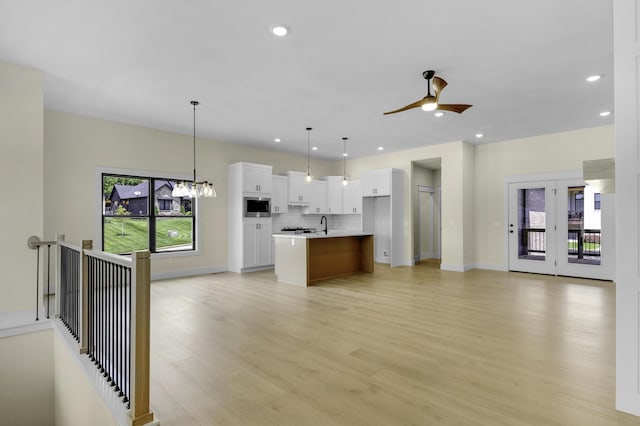 702 S Thornridge Dr, Springfield, MO 65809 - unfurnished living room featuring plenty of natural light, light wood-type flooring, ceiling fan, recessed lighting, and baseboards