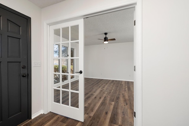 foyer featuring french doors, a textured ceiling, ceiling fan, and dark wood-type flooring