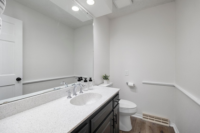 bathroom featuring hardwood / wood-style floors, vanity, and toilet