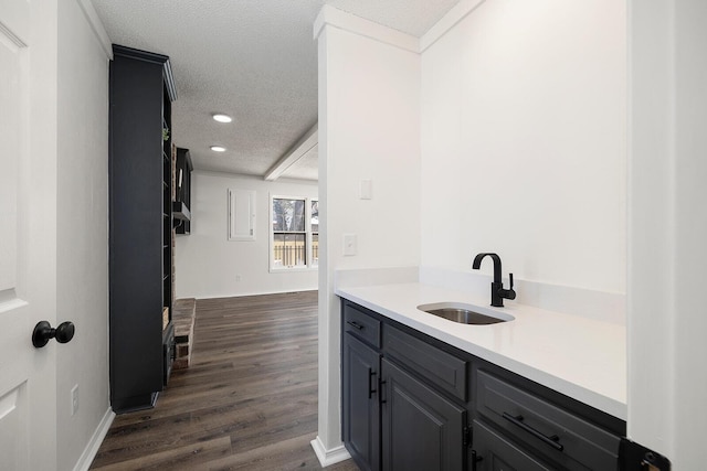 bar featuring gray cabinetry, sink, dark hardwood / wood-style floors, and a textured ceiling