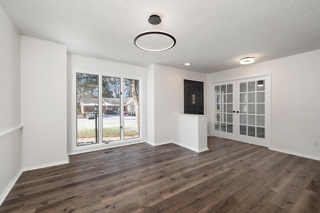 interior space with dark hardwood / wood-style flooring, french doors, and a textured ceiling