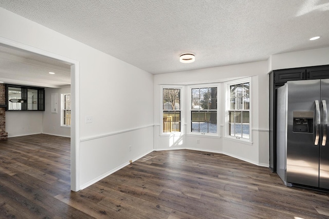 unfurnished dining area with dark hardwood / wood-style floors and a textured ceiling