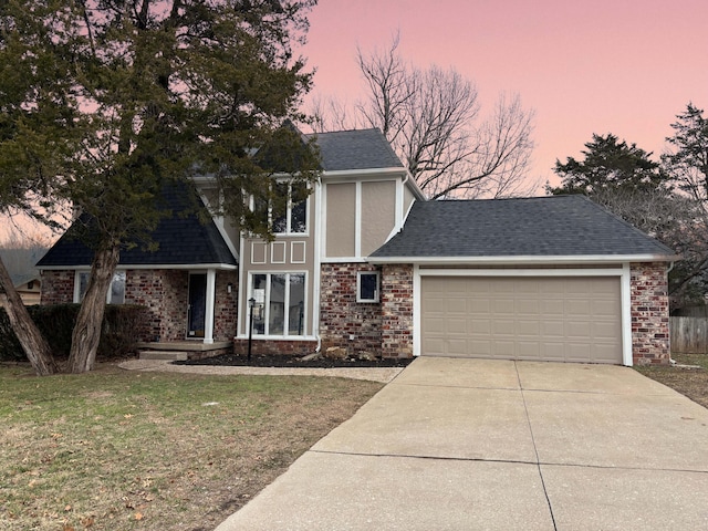 view of front of home with a garage and a lawn