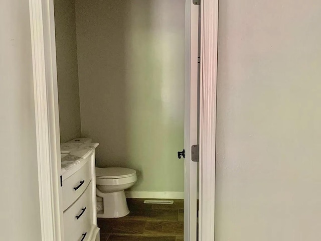 bathroom featuring wood-type flooring, vanity, and toilet