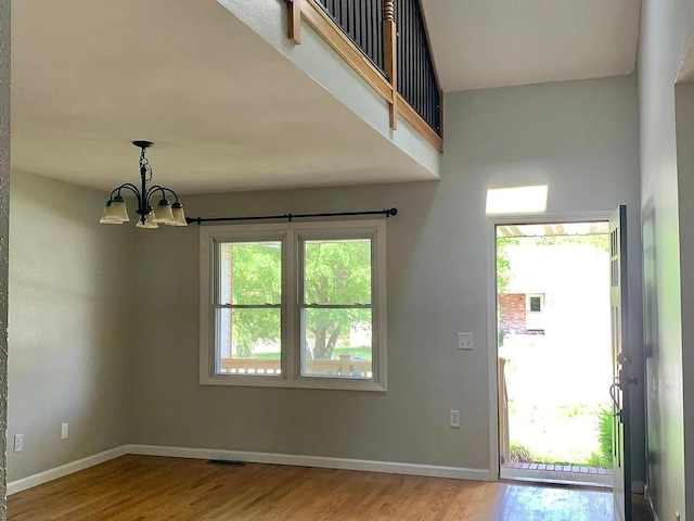 interior space featuring a healthy amount of sunlight, light hardwood / wood-style flooring, and a notable chandelier