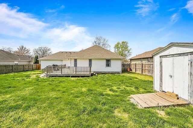 back of house with a storage unit, a lawn, and a wooden deck