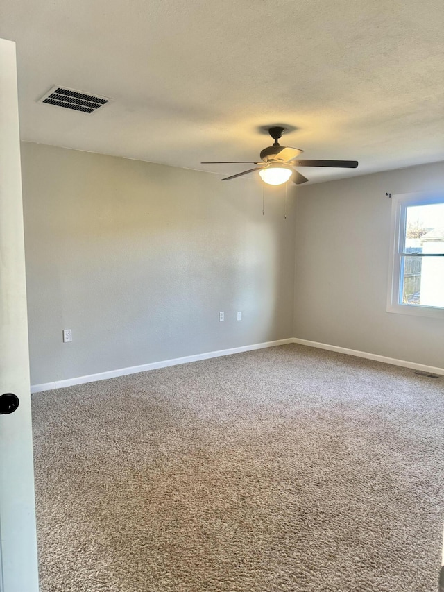 carpeted spare room featuring ceiling fan