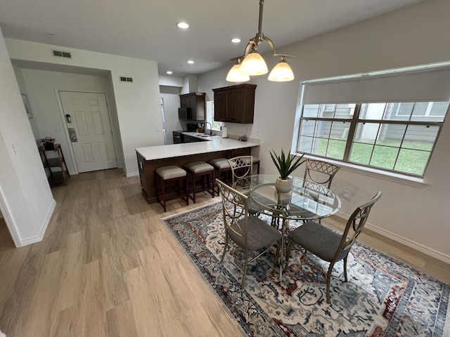 dining room featuring a chandelier, light hardwood / wood-style floors, and sink