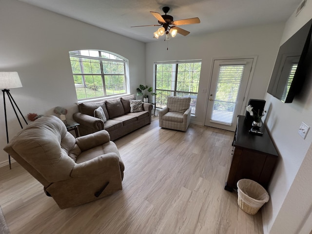 living room featuring ceiling fan, light hardwood / wood-style flooring, and a healthy amount of sunlight