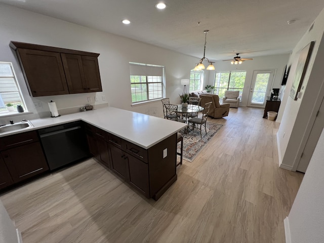 kitchen with kitchen peninsula, dark brown cabinetry, ceiling fan, dishwasher, and light hardwood / wood-style floors