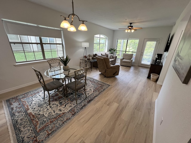 dining area featuring ceiling fan with notable chandelier and light wood-type flooring