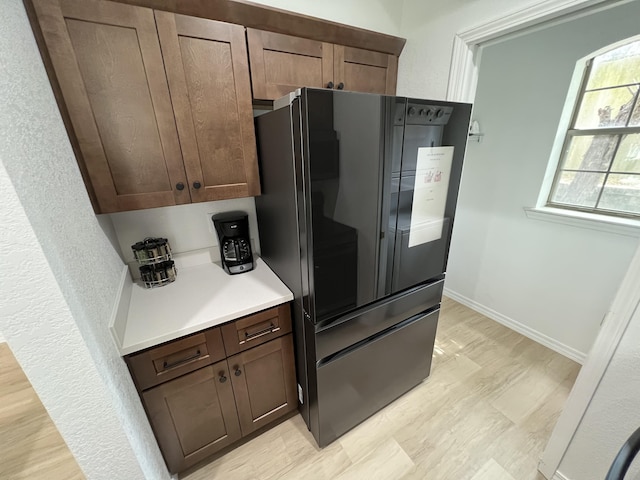 kitchen featuring black fridge and dark brown cabinetry