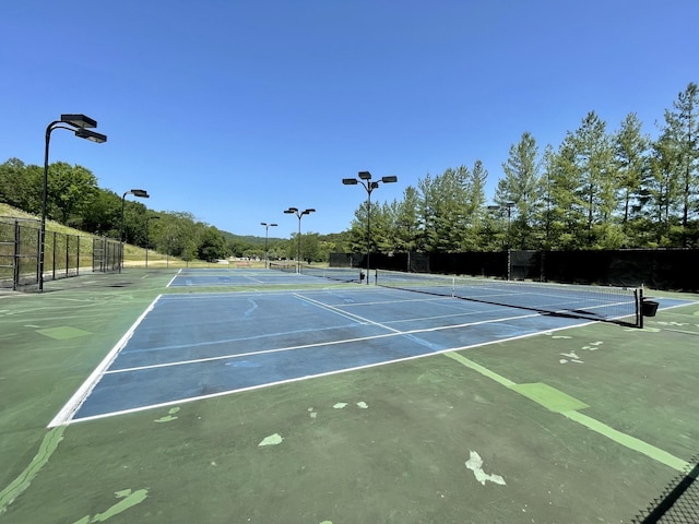 view of tennis court with basketball hoop