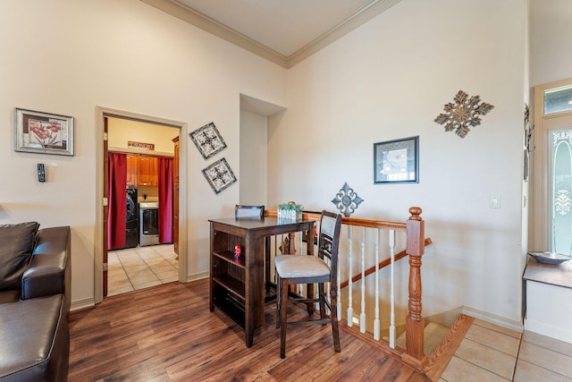 dining room featuring wood-type flooring, washer / clothes dryer, and crown molding