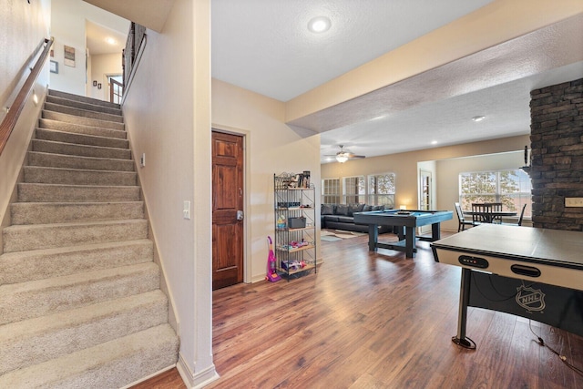 rec room with ceiling fan, wood-type flooring, a textured ceiling, and billiards