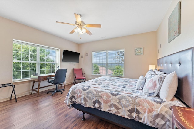 bedroom with dark hardwood / wood-style flooring and ceiling fan