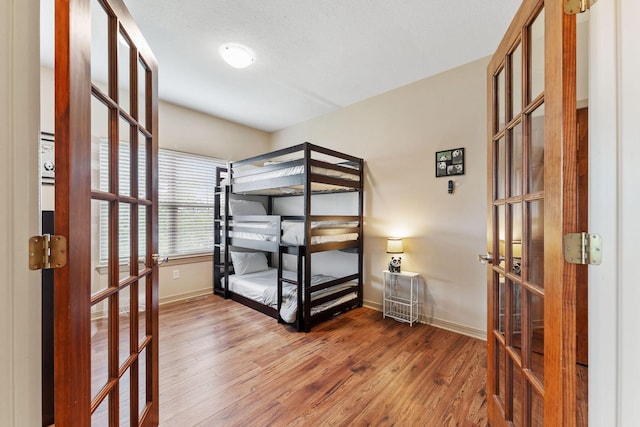 unfurnished bedroom with wood-type flooring and french doors