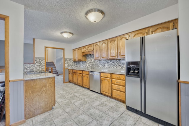 kitchen featuring backsplash, light tile patterned floors, and stainless steel appliances