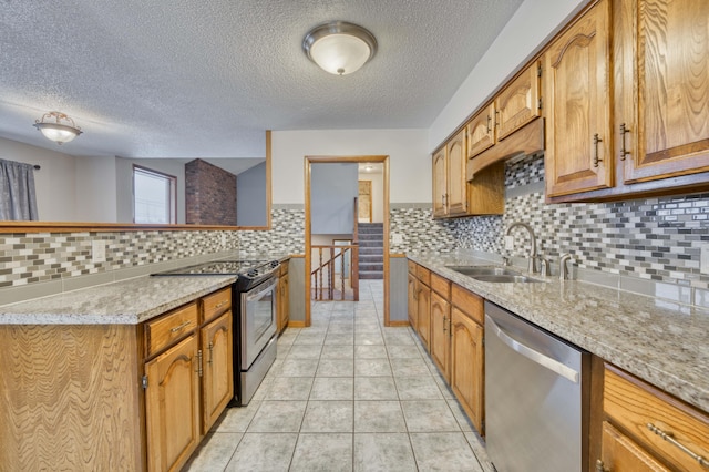 kitchen with sink, light stone counters, tasteful backsplash, and stainless steel appliances