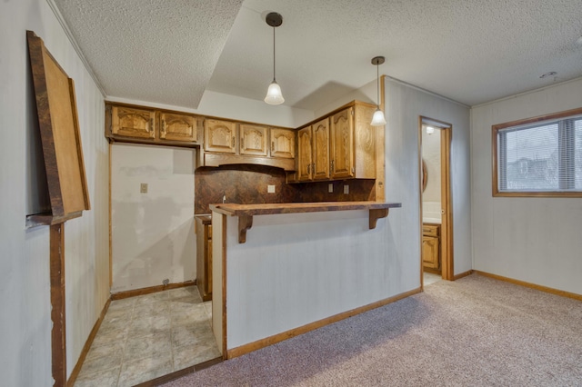 kitchen featuring kitchen peninsula, pendant lighting, light colored carpet, tasteful backsplash, and a kitchen bar