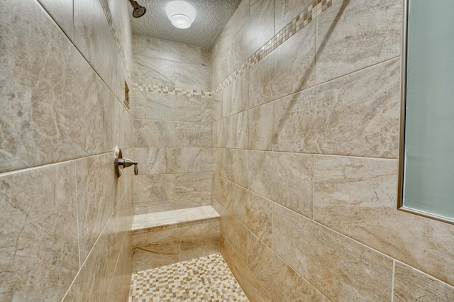 bathroom featuring a tile shower and a textured ceiling