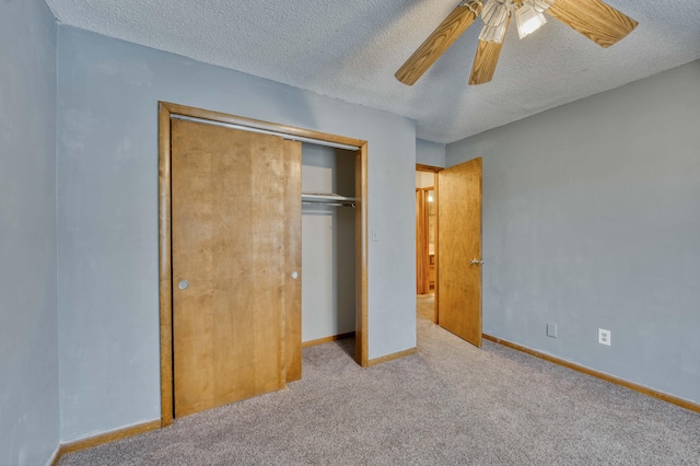 unfurnished bedroom featuring a textured ceiling, light colored carpet, a closet, and ceiling fan