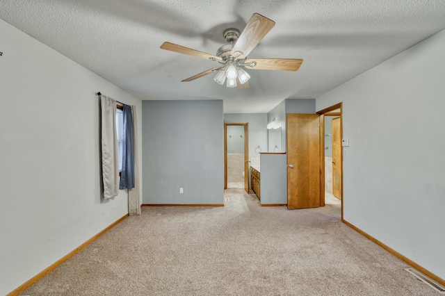 carpeted spare room with a textured ceiling and ceiling fan