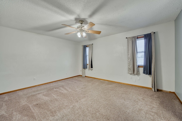 carpeted empty room featuring ceiling fan and a textured ceiling