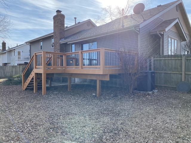 rear view of property featuring cooling unit and a wooden deck