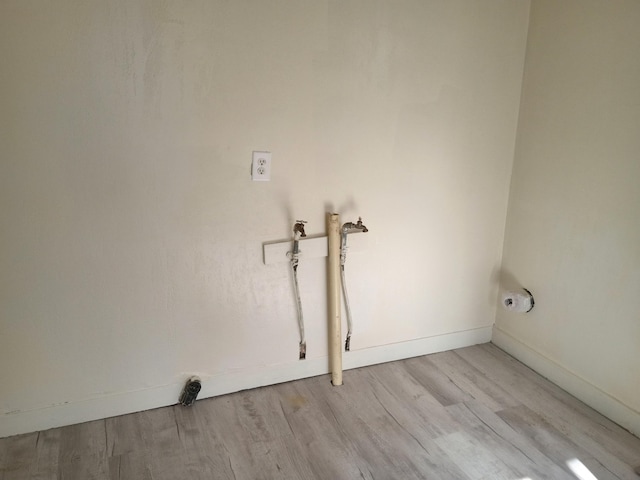 washroom with laundry area, light wood-style flooring, and baseboards