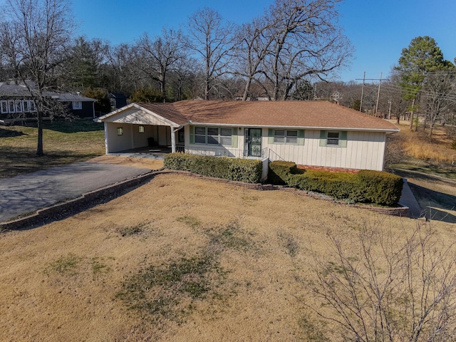 ranch-style house with a porch and driveway