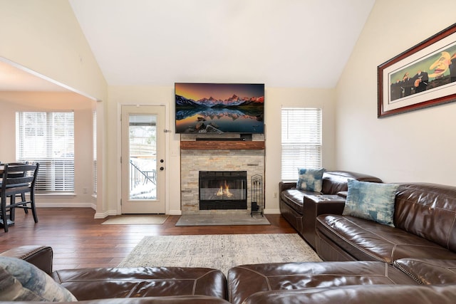 living room featuring dark hardwood / wood-style floors, a healthy amount of sunlight, a fireplace, and vaulted ceiling