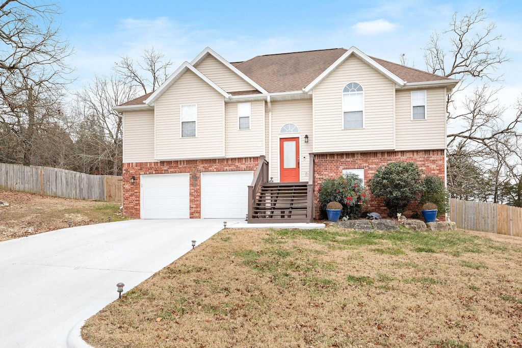 split foyer home with a garage and a front lawn