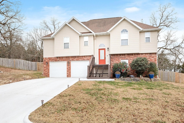 split foyer home with a garage and a front lawn