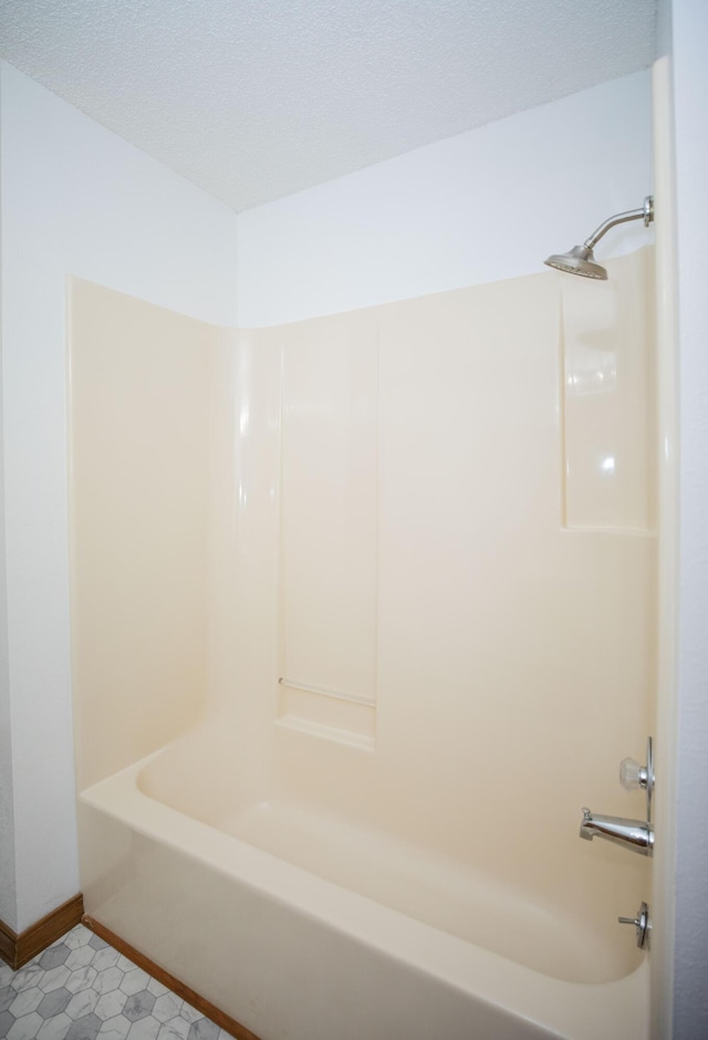 bathroom with tile patterned flooring and shower / bath combination