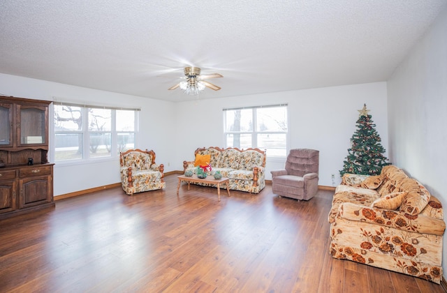 living room featuring a textured ceiling, dark hardwood / wood-style flooring, and ceiling fan